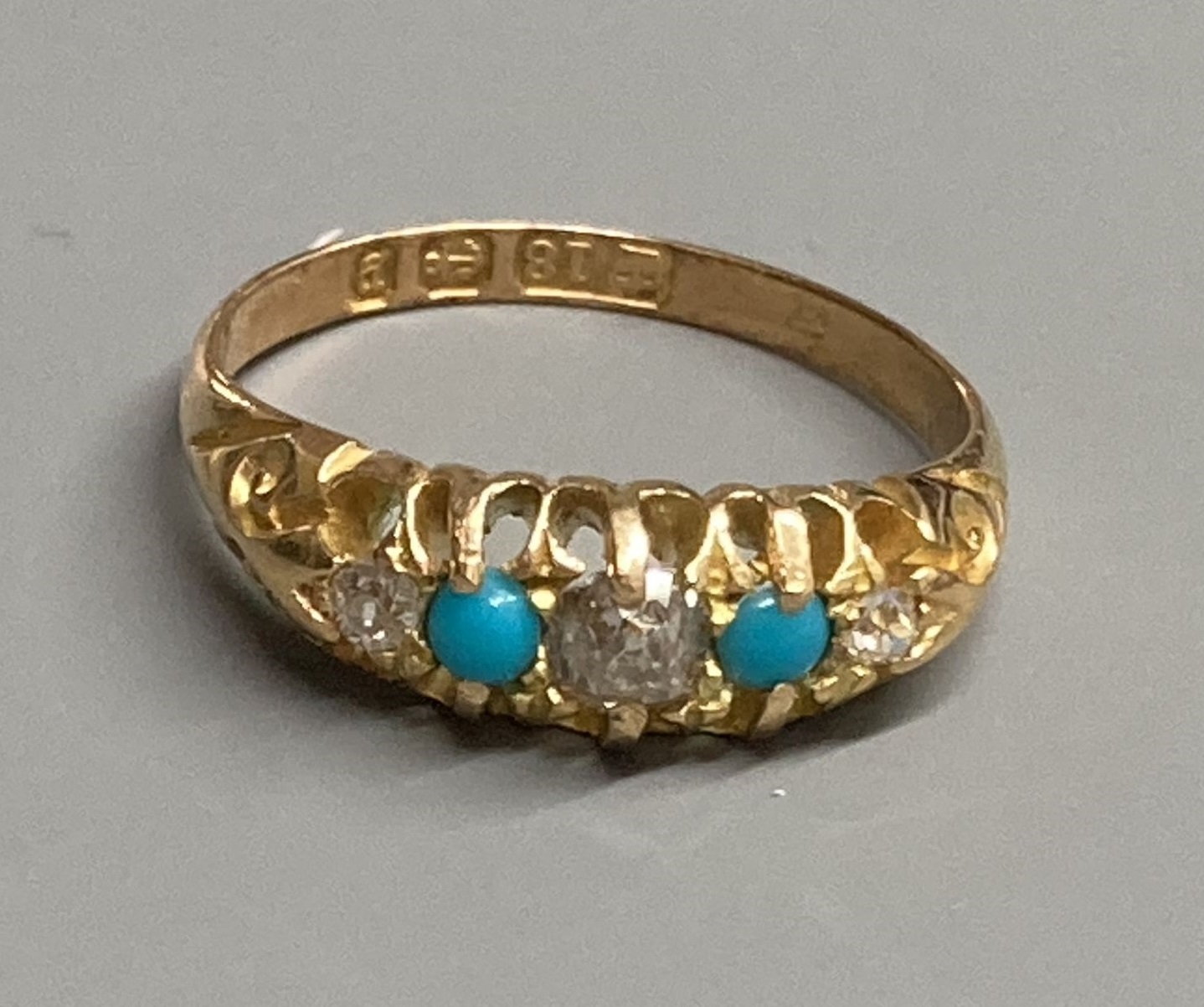 A late Victorian 18ct gold, three stone diamond and two stone turquoise set half hoop ring, size L, gross 3.4 grams.